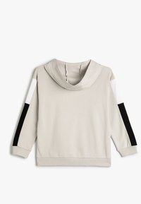 Sudadera ligera de color gris claro con un gran cuello de tipo cowl, que presenta acentos de rayas en blanco y negro contrastantes en las mangas. Fabricada con tela suave, con un dobladillo acanalado.