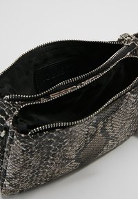 Borsa in ecopelle effetto serpente a trama nera e grigia con due scomparti, chiusura con cerniera argentata e fodera interna in tessuto nero morbido.