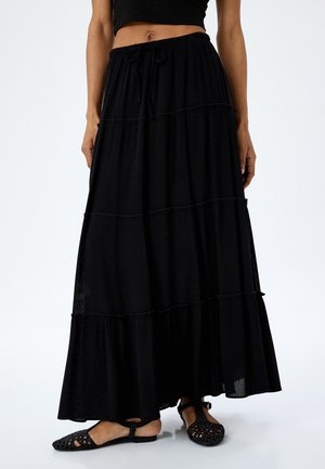 Zwarte maxi rok met meerdere lagen, voorzien van een elastische tailleband en een trekkoord. Gemaakt van lichtgewicht stof, met een vloeiende uitstraling en een gemêleerd afwerking.