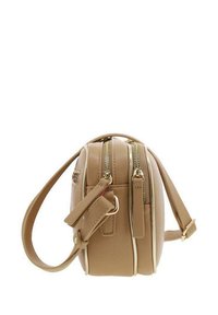 Sac en cuir tan à bandoulière avec deux compartiments zippés et une sangle amovible. Forme ronde avec une texture lisse et des accessoires en métal doré.