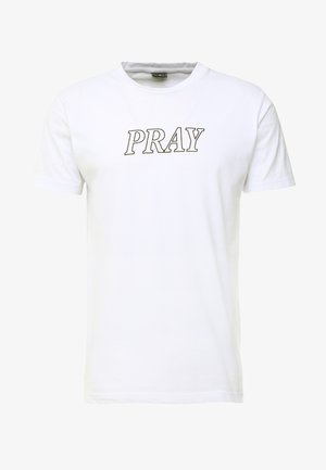 White cotton t-shirt featuring short sleeves and the word "PRAY" printed in a bold, outlined black font across the chest.