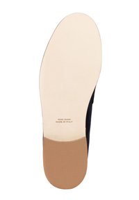 Suola di una scarpa elegante con fondo in pelle beige, tacco texturizzato color nocciola e la dicitura "Vero Cuoio Made in Italy" impressa sulla pelle.