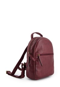 Burgundy leather backpack with a rounded shape, front zip pocket, adjustable strap, and top handle. Smooth texture and subtle branding detail.