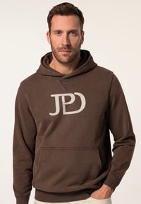 Felpa cappuccio marrone con tasca anteriore, caratterizzata da un grande logo bianco. Tessuto morbido con polsini e orlo a costine, vestibilità casual.