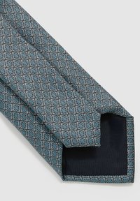 Cravate texturée en teal et marine, présentant un motif géométrique en losanges. Fabriquée en tissu tissé, avec une finition lisse et une pointe effilée.