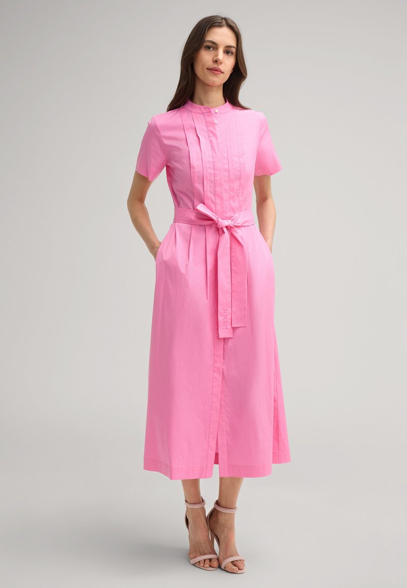 Rosa Hemdkleid aus Baumwolle, mit hohem Kragen, gefälteltem Vorderteil, kurzen Ärmeln, einem Bindegürtel und seitlichen Taschen.