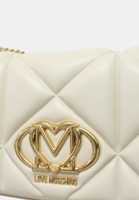 Borsa a tracolla in ecopelle bianca trapuntata con hardware logo dorato e tracolla a catena, caratterizzata da una texture liscia e un motivo a diamante.