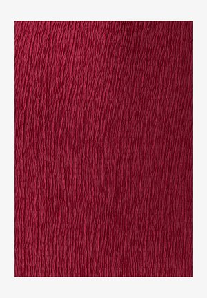 Material rojo texturizado con una superficie arrugada y profundos surcos que crean un patrón táctil. El color es un carmesí intenso y profundo.