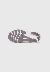 Semelle de chaussure en caoutchouc violet flexible avec des motifs texturés et des accents blancs, offrant une adhérence et une traction pour une utilisation active.