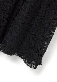 Tejido de encaje negro con intrincados patrones florales y un borde ondulado, mostrando un diseño texturizado y en capas. Ligero y delicado.