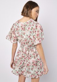 Blumenkleid mit kurzen Puffärmeln, gerafftem Taillenbund, leichtem Stoff mit pinken und grünen Blumen auf einem sanften mintfarbenen Hintergrund.