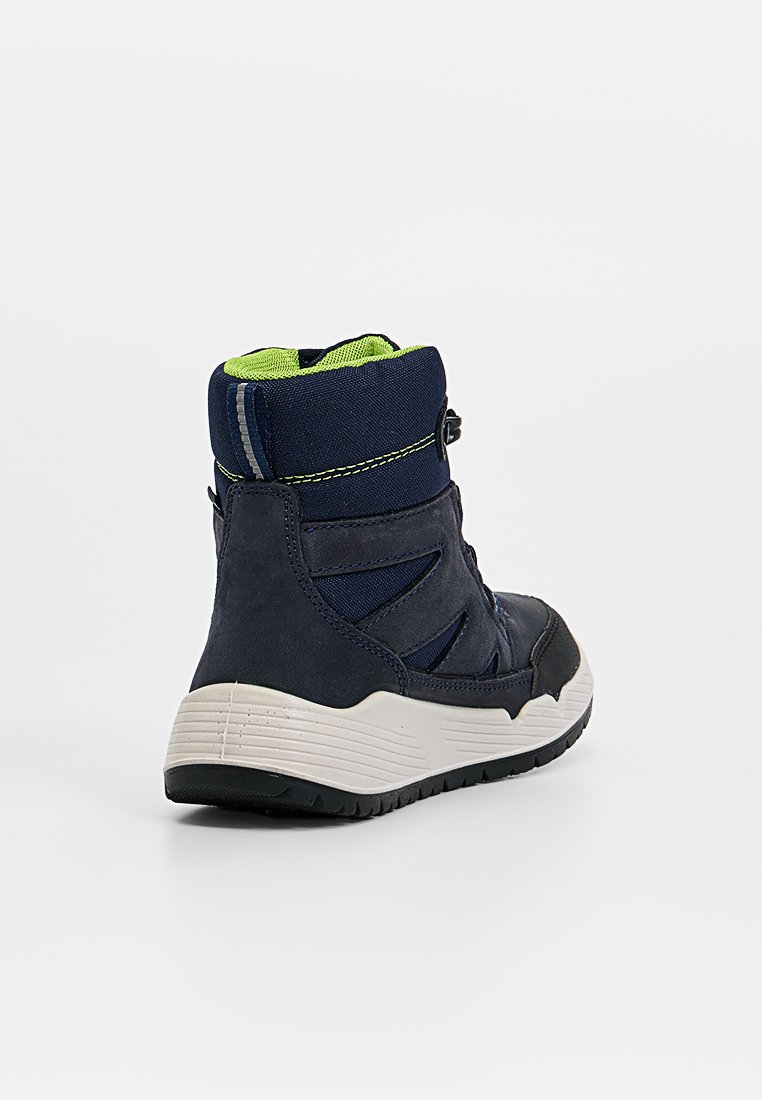 Marineblau und schwarze High-Top-Sneaker mit limonengrüner Innenauskleidung, weißer dicke Sohle und strukturiertem Profil, aus einer seitlichen Rückansicht gezeigt.