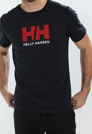 Mann trägt ein schwarzes T-Shirt mit großem rotem "HH" und dem Markennamen "HELLY HANSEN" in Weiß auf der Brust.