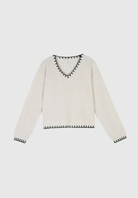 Pull en tricot de couleur crème avec un col en V, bordé de noir au niveau de l'encolure, de l'ourlet et des manches, avec des manches longues et une coupe courte.