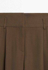 Pantalon marron taille haute avec passants pour ceinture et fermeture avant cachée, visible de la taille vers le bas.