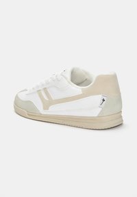 Sneaker bianco con dettagli in suede beige. Parte superiore in pelle liscia, design con lacci, punta rotonda e suola in gomma con motivo di battistrada texturizzato.