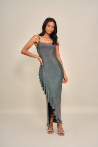 Skinnende grå kjole med en tettsittende overdel og asymmetrisk volangkant, som har tynne stropper og en sidespalte.