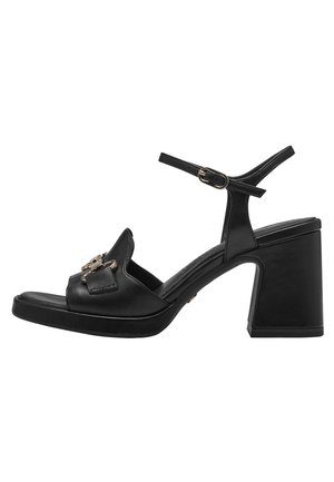 Sort læder sandal med høj hæl, chunky hæl, åben tå og justerbar ankelrem. Har dekorative gulddetaljer.