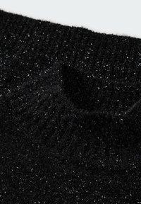 Mustat kiiltävät pooloneuleet pehmeästä, teksturoidusta kankaasta, jossa on metallinhohtoisia säihkeitä. Neulekuvio lisää syvyyttä ja ulottuvuutta.