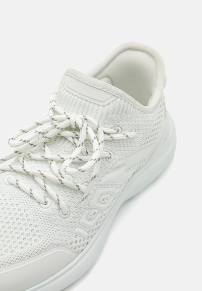 Witte sportschoen met een bovenwerk van mesh, een gestructureerd breipatroon en platte veters. Voorzien van een gladde rubberen zool en subtiele logo-accenten.