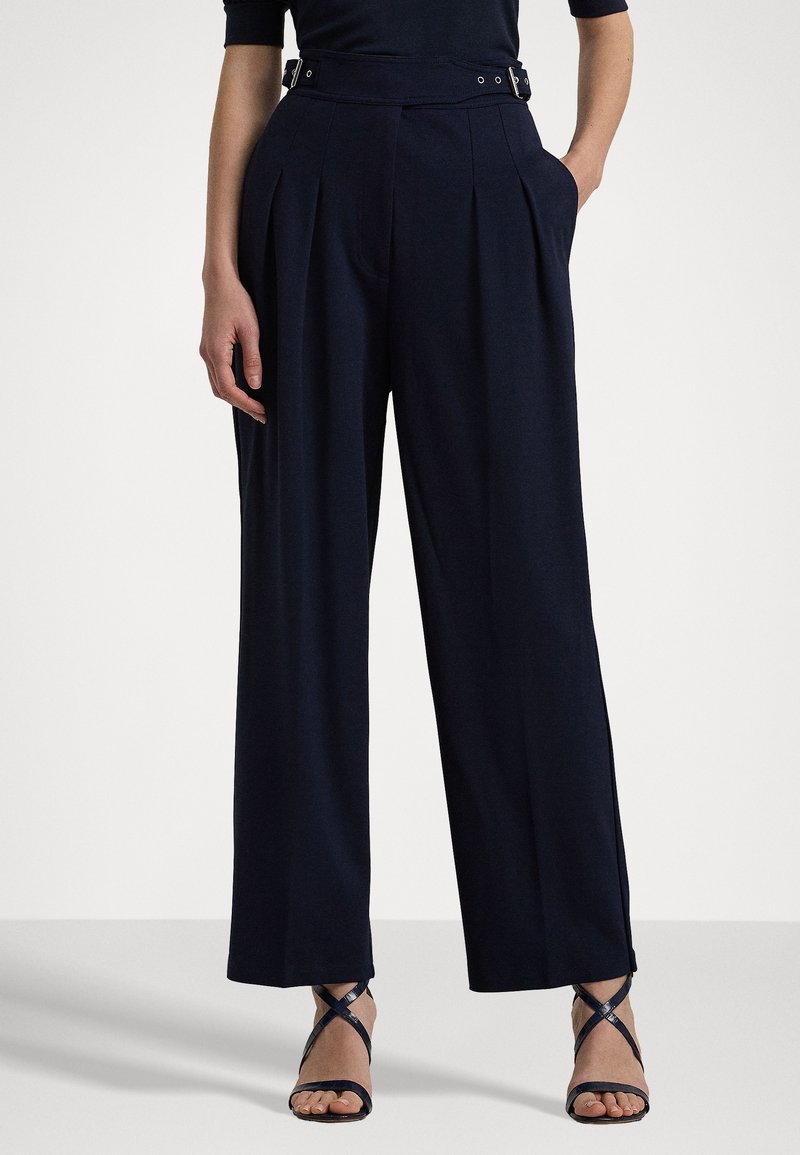 Pantaloni a gamba larga color navy con pieghe, vita alta e passanti per la cintura. Tessuto morbido; presenta tasche laterali e un orlo pulito.