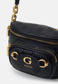 Schwarze strukturierte Handtasche mit goldenen Akzenten, featuring eine Reißverschlussöffnung, Logo-Details und einem Kettenriemen.