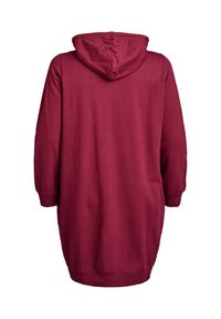 Abito felpa con cappuccio color marsala, maniche lunghe, vestibilità ampia e polsini a costine. Tessuto morbido, arriva a metà coscia in lunghezza.