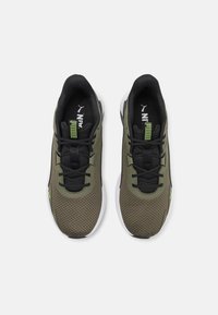 Idrottsskor med ett svart och olivgrönt nätöverdrag, svarta snören och vit sula. Har en grön accent på sidan och ett märke.