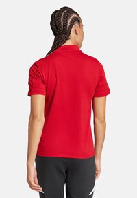 Polo shirt rossa con maniche corte e colletto strutturato, realizzata in un tessuto liscio. Presenta un design semplice e una silhouette aderente.