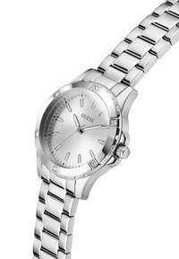 Montre Guess argentée avec un bracelet en métal poli, dotée d'un cadran minimaliste et d'accents en diamant sur la lunette.