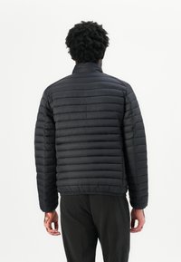 Zwarte pufferjack met horizontale stiksels, hoge kraag en elastische manchetten. Beschikt over een slim fit en een ingezamelde zoom. Geschikt voor koud weer.