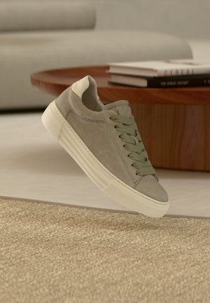 Hellgrauer Wildleder-Sneaker mit abgerundeter Spitze, weißer Sohle und hellgrünen Schnürsenkeln. Verfügt über ein minimalistisches Design und eine glatte Textur.