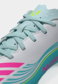 Φωτεινό γαλάζιο παπούτσι με ροζ και πράσινες λεπτομέρειες. Λείο συνθετικό υλικό, στρογγυλεμένη μύτη και υφή στη σόλα. Διαθέτει επίπεδα κορδόνια και λογότυπο.