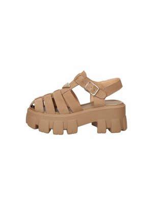 Sandalo chunky color cuoio con suola spessa carrarmato, più cinturini e chiusura con fibbia regolabile sul lato.