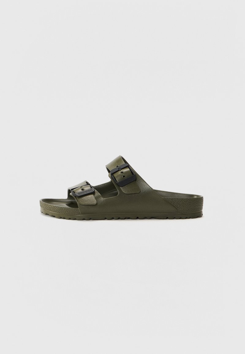 Green slide sandal made of rubber, featuring two adjustable straps with black buckles, a textured footbed, and a treaded sole.