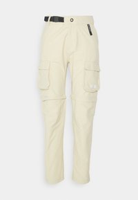 Beige cargo-housut, joissa on vetoketjulla irrotettavat lahkeet, läpälliset taskut reisissä, musta säätövyö ja The North Face -logo oikeassa taskussa.