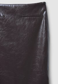 Dunkelbrauner, glänzender Kunstlederrock mit einer gewellten Textur, der ein schlichtes Design aufweist und eine Rückentasche am Bund hat.