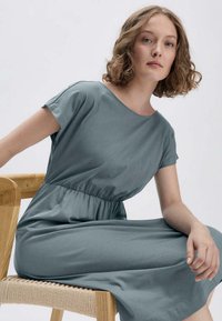 Graues, knielanges Kleid aus weichem Stoff mit rundem Halsausschnitt und kurzen Ärmeln; verfügt über einen elastischen Bund für eine lässige Passform.