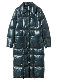 Polstret frakke i blank mørk teal med forlommer med klap, knapper foran og krave. Elegant, quiltet design.