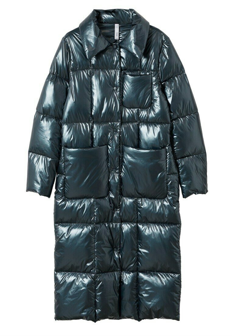 Abrigo acolchado en verde azulado oscuro brillante, con cierre frontal de botones, grandes bolsillos de parche y cuello. Diseño elegante y acolchado.
