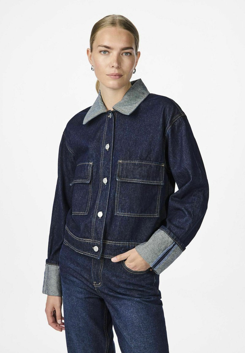  farkkutakki harmaalla kauluksella ja hihoilla, jossa on kaksi etutaskua, napit ja erottuva ommel. Suora pinta, tummansininen väri.