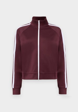 Giacca borgogna con zip e colletto alto, strisce laterali bianche e polsini a costine. Realizzata in materiale liscio e leggero.