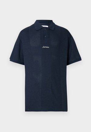 Polo bleu marine en tissu texturé. Comprend des manches courtes, un col classique et une patte de devant avec deux boutons. Logo "Samsøe" affiché.