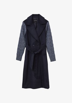 Manteau trench bleu marine foncé avec un col à revers, des boutons double-breasted et des manches en tricot texturé. Dispose d'une taille ceinturée et de poches latérales.