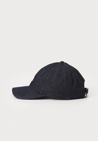 Sötét farmer baseball sapka ívelt karimával, hímzett logóval elöl és állítható pánttal hátul. Texturált anyag.