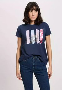 Granatowa bawełniana koszulka z abstrakcyjnym wzorem graficznym w różowych, jasnoniebieskich i czerwonych paskach, z motywem liścia w złotych akcentach.