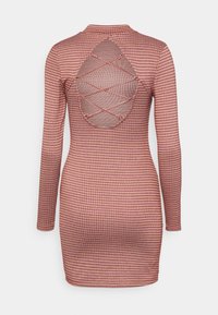 Vestido ajustado de manga longa em padrão de quadrados vermelhos e creme, com uma abertura em forma de olho-chave nas costas e detalhes em tecido cruzado.