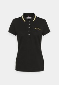 Sort polo shirt med korte ærmer, guldtrim på kraven, knaplukning og broderet logo i guld på venstre side. Blødt stoftekstur.