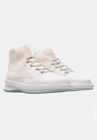 Hvide høj-top sneakers med en struktureret overdel, grønne detaljer og en gennemsigtig sål. Har lette snørebånd og forstærket syninger.