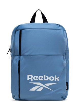 Niebieski plecak Reebok z dwoma pionowymi czarnymi kieszeniami zapinanymi na zamek oraz białym logo Reebok na przedniej kieszeni.